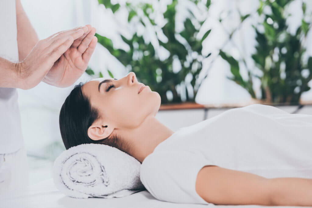 Cropped Shot Of Calm Young Woman With Closed Eyes Receiving Reiki Treatment